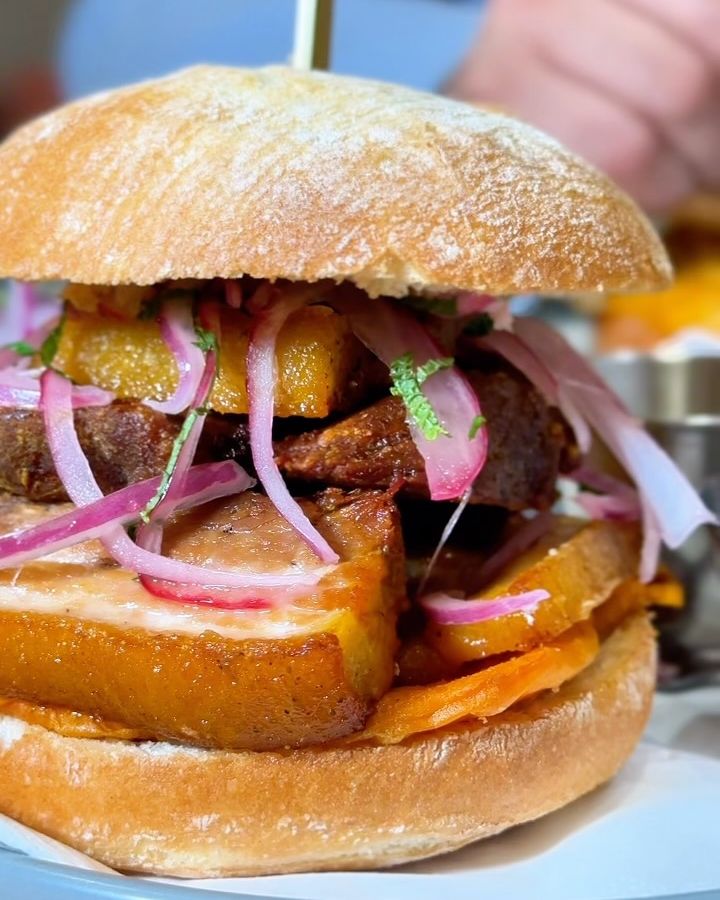 Sánguche de Nazca con chicharrón, boniato y salsa criolla, pinchado con un palillo